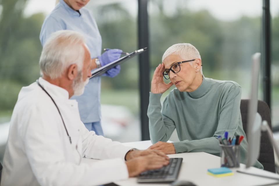 Doctor talking with an elderly patient in a bright clinic