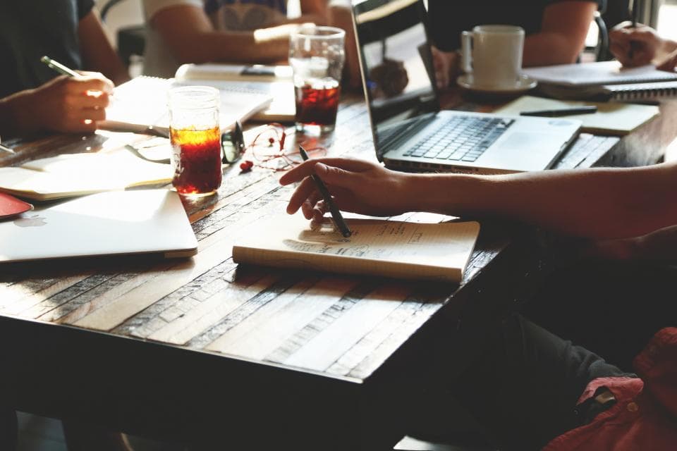 Startup team working together around a table with laptops and notebooks